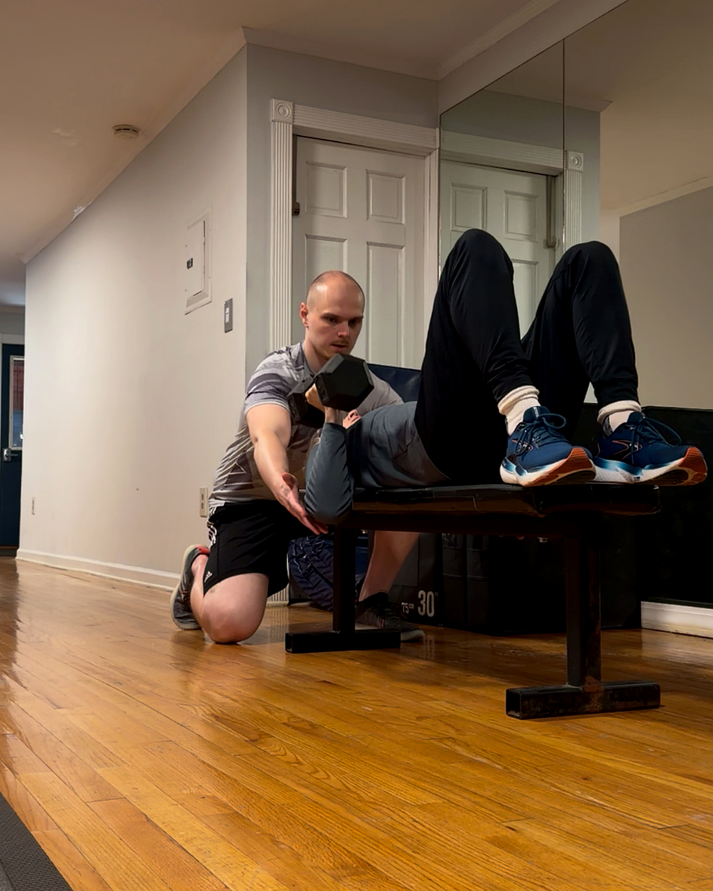 Daniel coaching and spotting a client during a dumbbell chest press